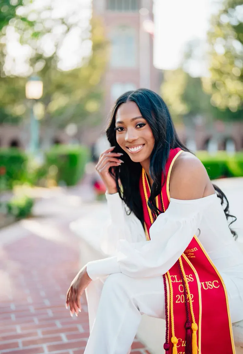 Graduation portrait sitting by fountain at USC