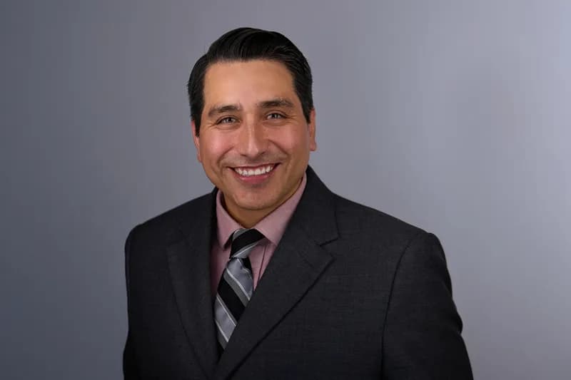Professional headshot of a woman in a blazer, direct confident expression