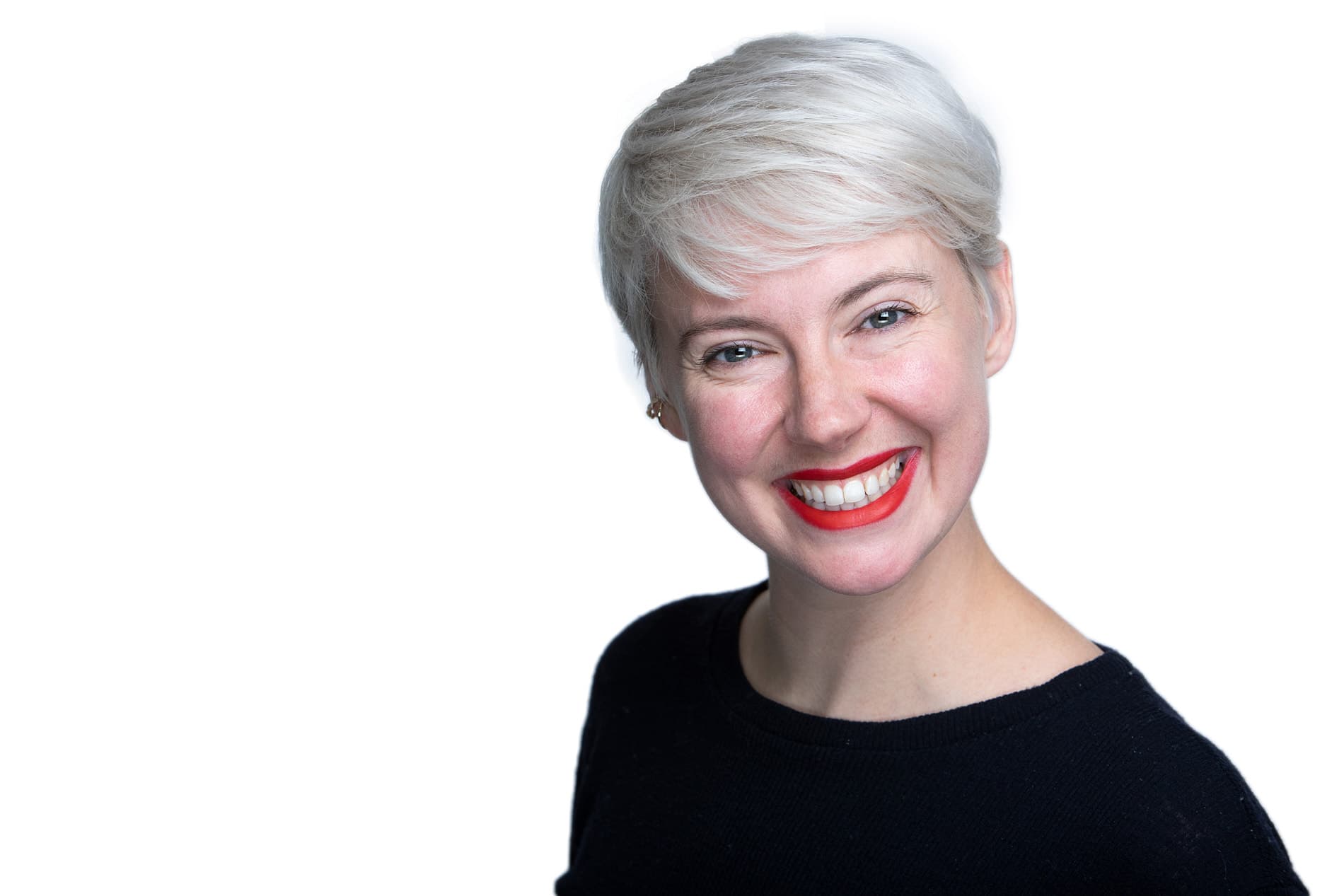 Professional headshot of woman with short platinum blonde hair, red lipstick and black top against white background