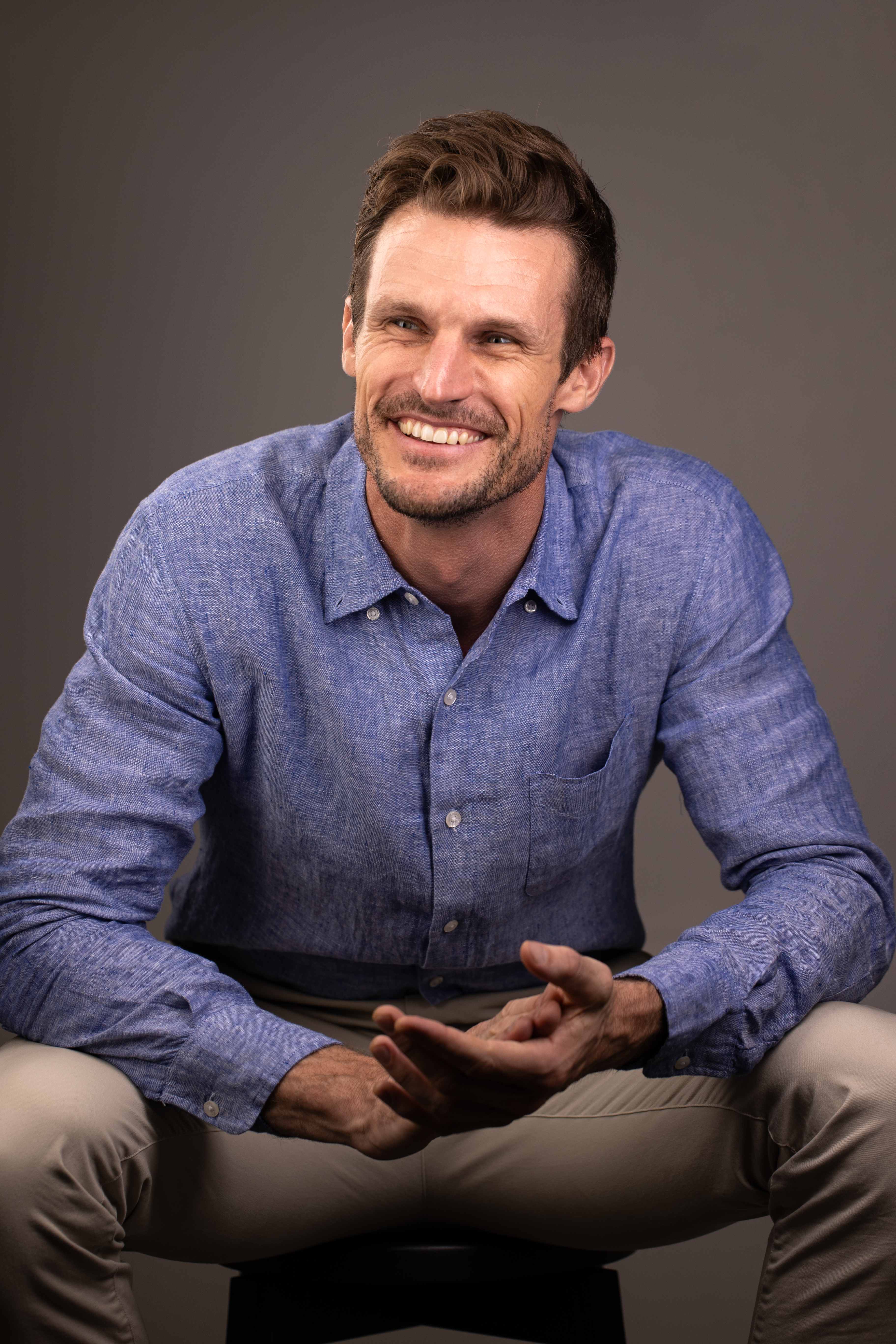 Professional headshot of Scott Thorne in a blue linen shirt with a friendly smile