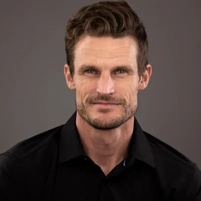 Professional headshot of man in black shirt
