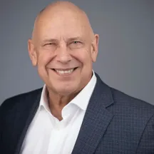 Professional headshot of man in navy suit