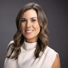 Professional headshot of woman in white top