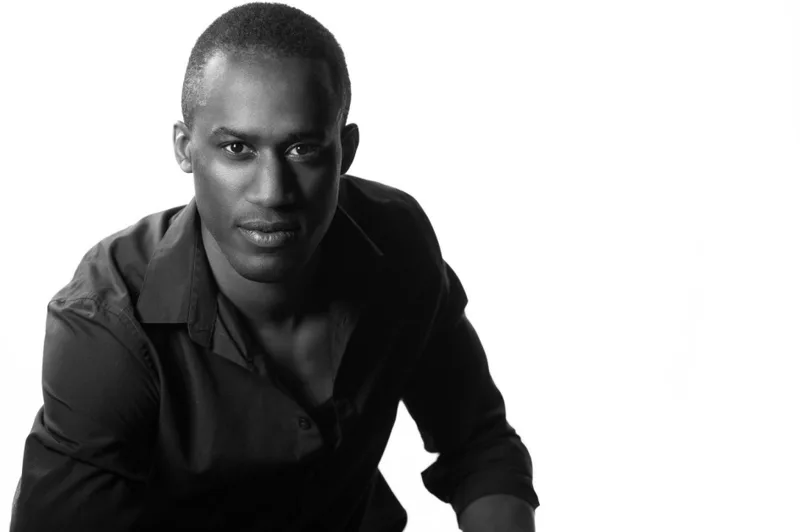 Professional headshot of man in dark clothing