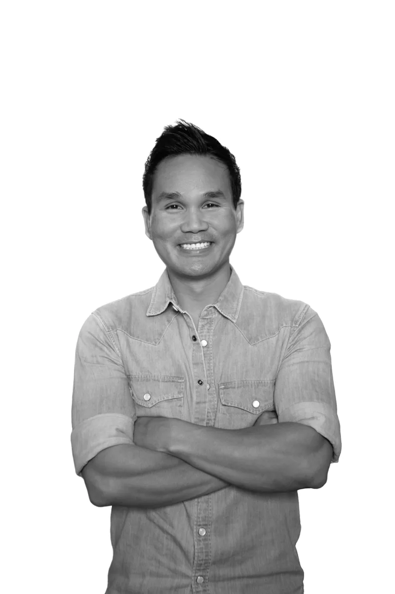 Professional headshot of Asian man in denim shirt