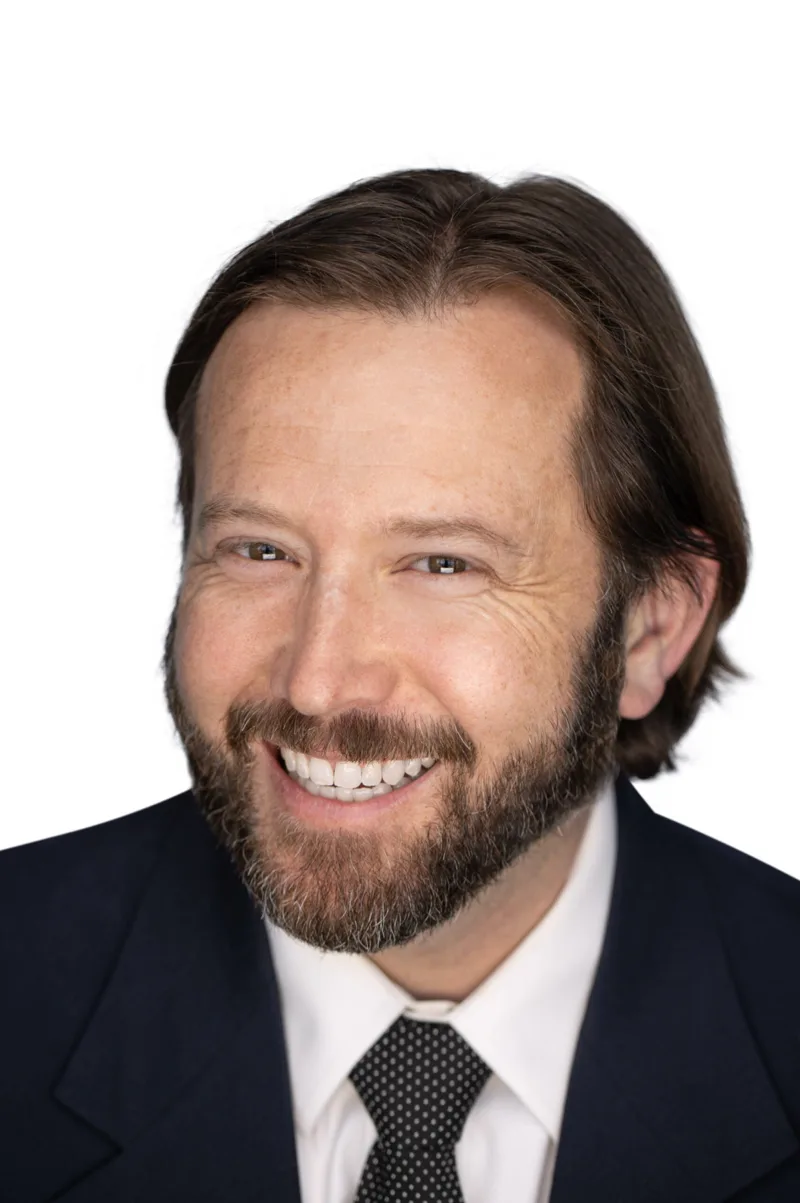 Professional headshot of man with longer hair
