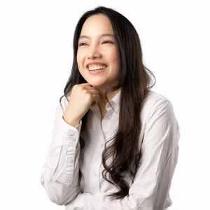 Professional headshot of a young Asian woman with long dark hair wearing a white button-up shirt